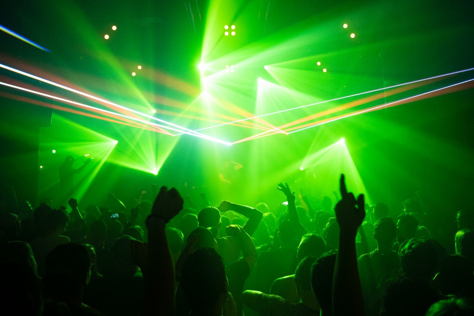 People dancing at a club night under green lights
